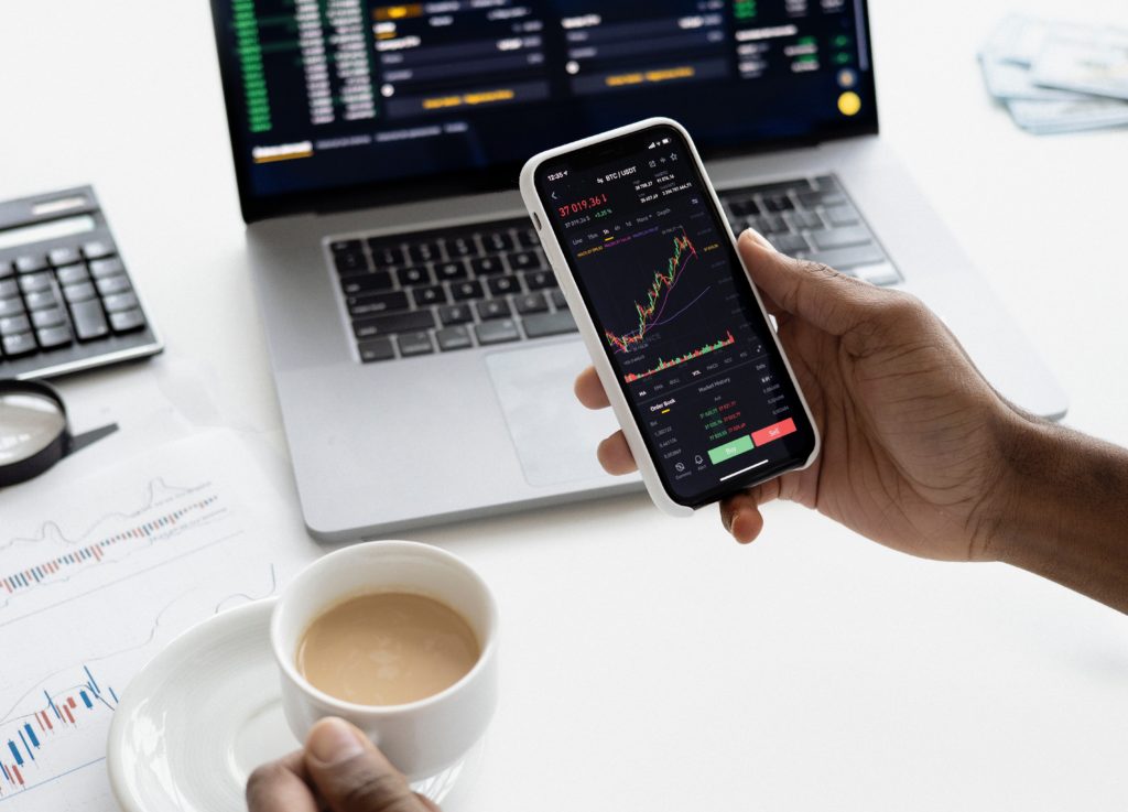 A man holding is phone and watching his trading.